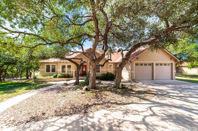 view of front facade featuring a garage, concrete driveway, and stucco siding