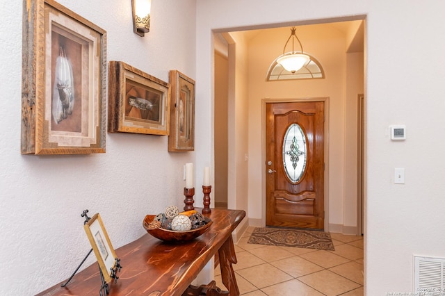 entrance foyer featuring light tile patterned floors, baseboards, and visible vents