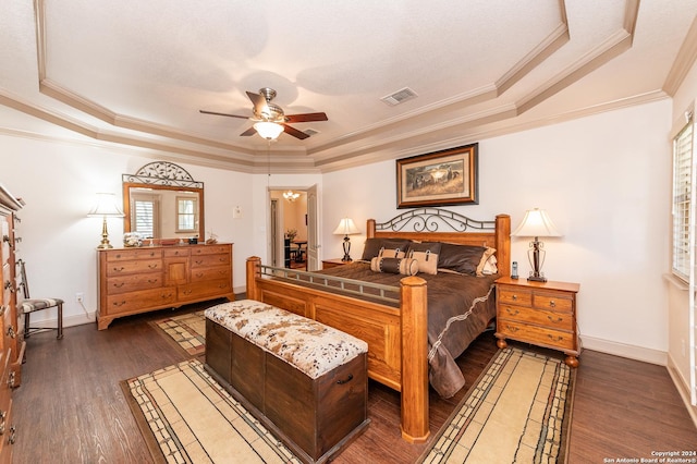 bedroom with a raised ceiling, visible vents, and dark wood-style flooring