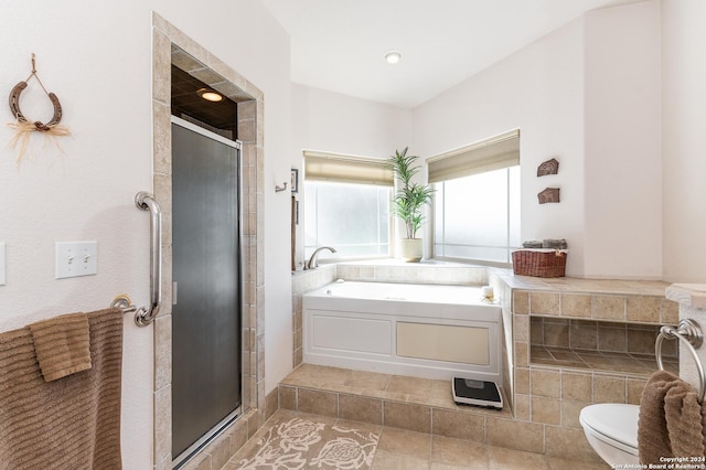 bathroom featuring a stall shower, a garden tub, and toilet