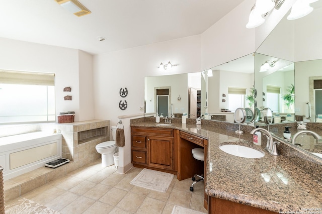 bathroom featuring a bath, a shower stall, double vanity, and a sink