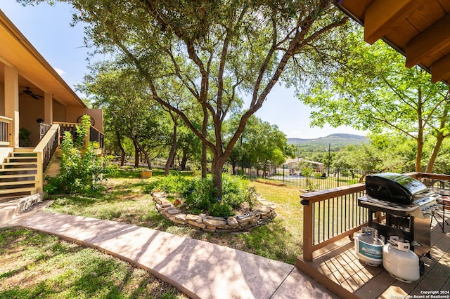 view of yard featuring stairs, a deck with mountain view, and fence