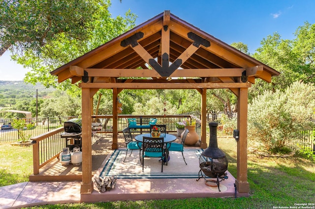 view of patio / terrace featuring an outdoor fire pit, fence, a deck, and a gazebo