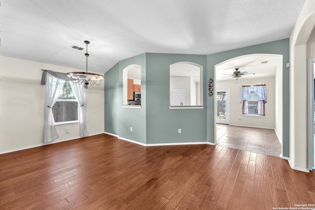 interior space with ceiling fan with notable chandelier and hardwood / wood-style flooring