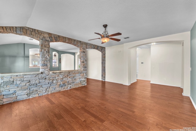 unfurnished living room featuring ceiling fan, lofted ceiling, a textured ceiling, and wood-type flooring