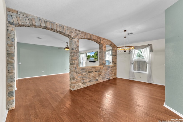 unfurnished living room featuring hardwood / wood-style floors and ceiling fan with notable chandelier