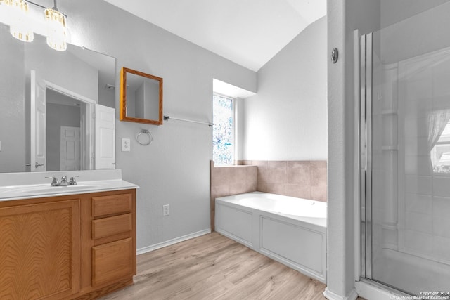 bathroom featuring vaulted ceiling, vanity, hardwood / wood-style floors, and shower with separate bathtub