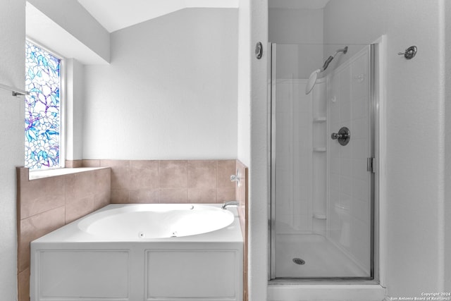 bathroom featuring vaulted ceiling and shower with separate bathtub