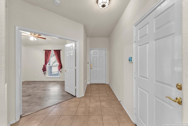 entryway with light tile patterned flooring and ceiling fan