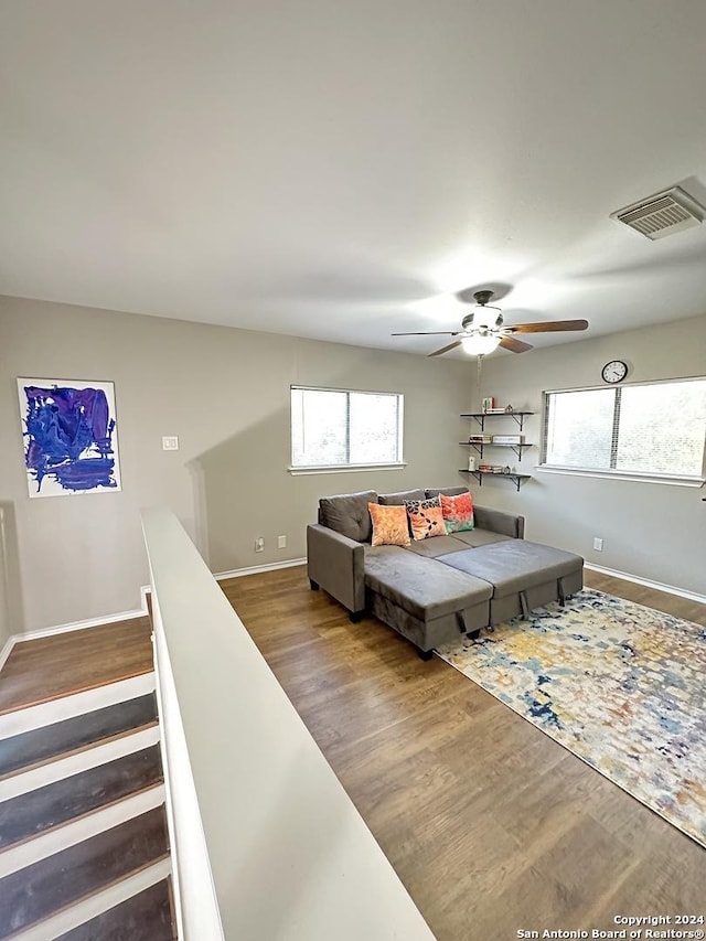 interior space with baseboards, wood finished floors, visible vents, and a healthy amount of sunlight