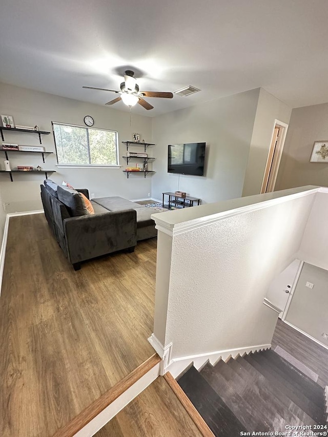 living area featuring ceiling fan, visible vents, and wood finished floors