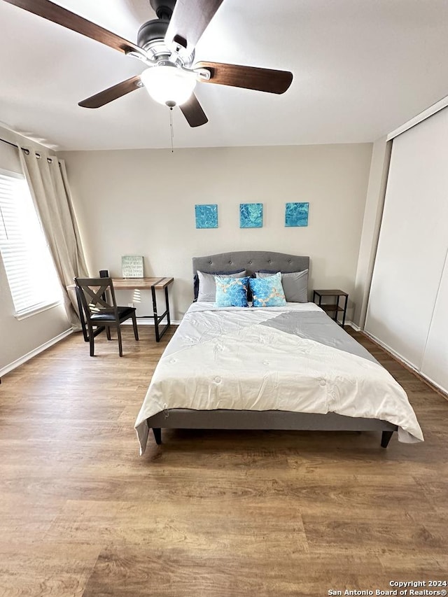 bedroom with baseboards, a closet, a ceiling fan, and wood finished floors