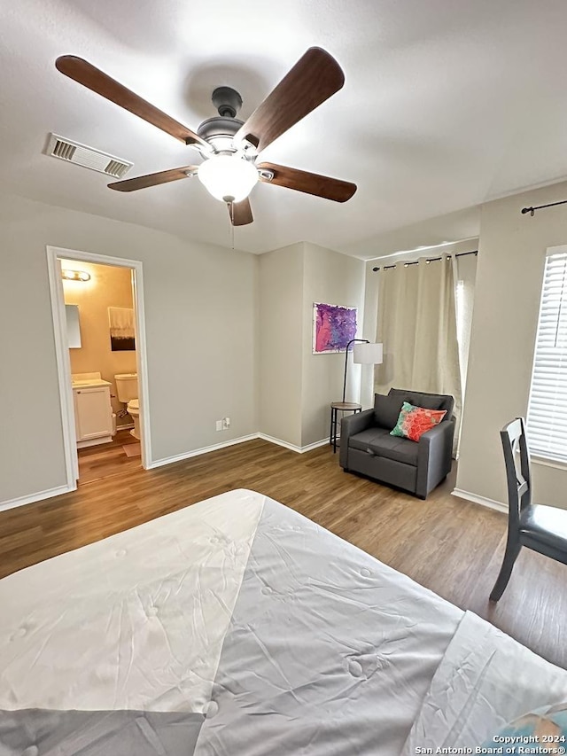 bedroom featuring a ceiling fan, baseboards, visible vents, and wood finished floors