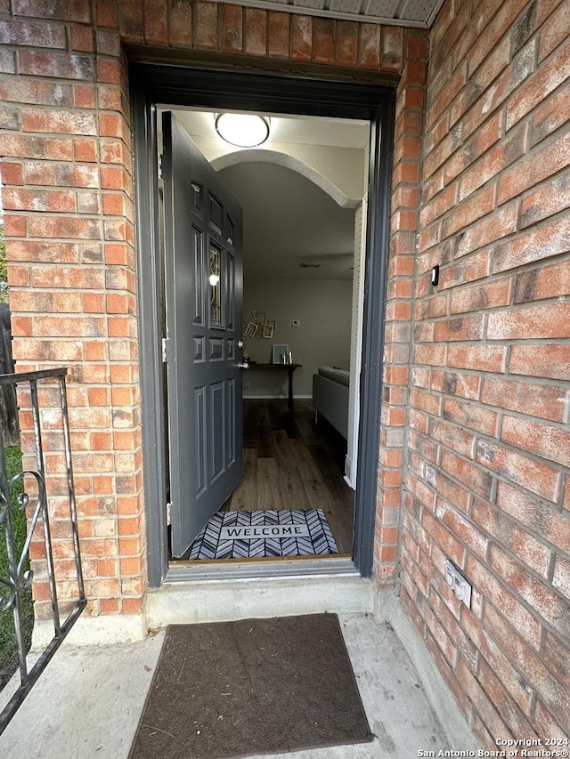 doorway to property with brick siding