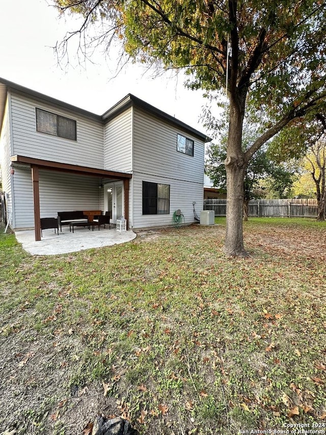 rear view of property with a yard, central AC unit, a patio area, and fence