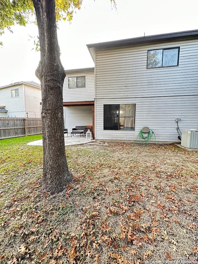 rear view of property featuring a patio area, a yard, cooling unit, and fence