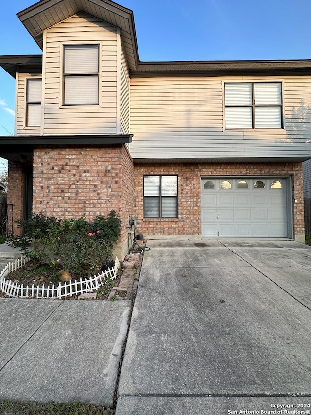 view of front of house with concrete driveway, brick siding, and an attached garage