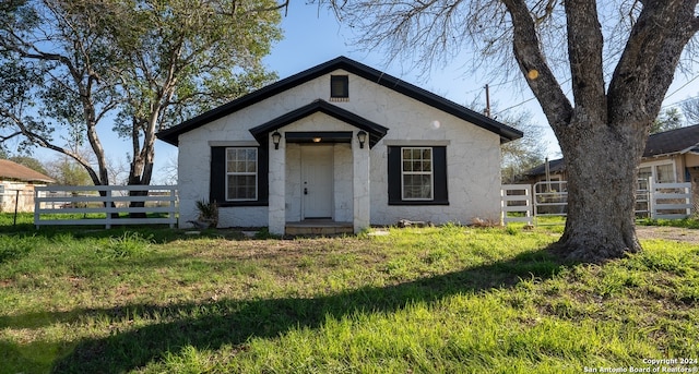 bungalow-style home with a front lawn