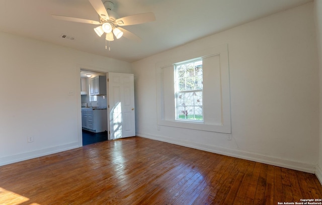 empty room with ceiling fan and dark hardwood / wood-style floors