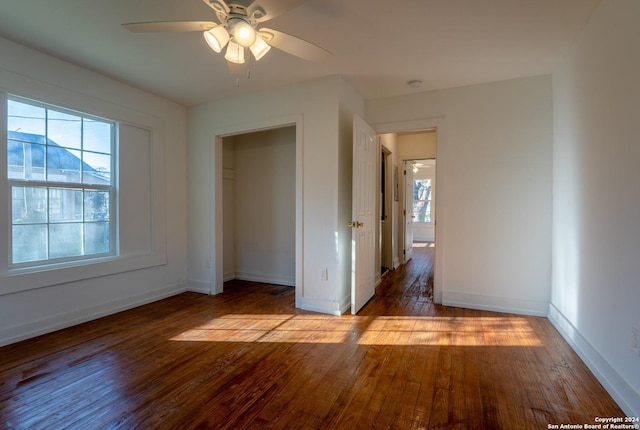 unfurnished bedroom featuring multiple windows, ceiling fan, and wood-type flooring