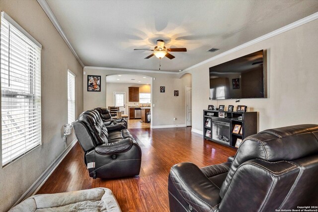 living room featuring dark hardwood / wood-style flooring, crown molding, and ceiling fan