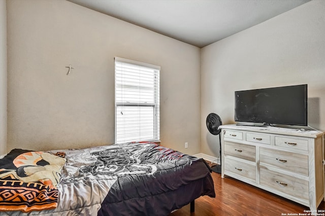 bedroom with dark hardwood / wood-style floors