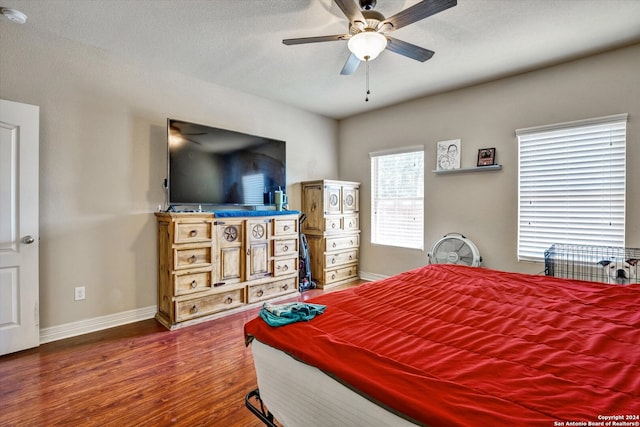 bedroom featuring a textured ceiling, ceiling fan, and dark hardwood / wood-style flooring