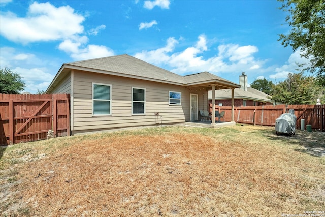 rear view of property featuring a yard