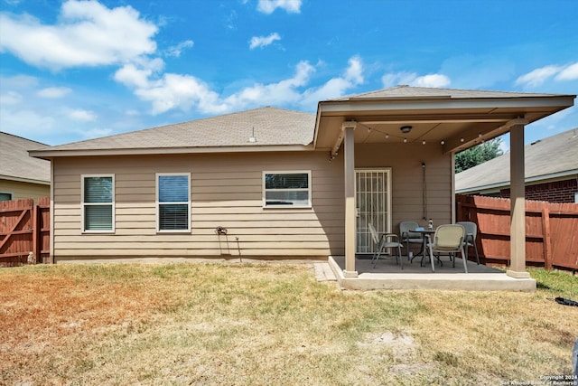 rear view of property featuring a patio area and a yard