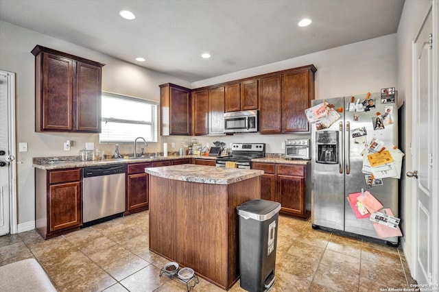 kitchen with sink, a center island, light tile patterned flooring, and stainless steel appliances