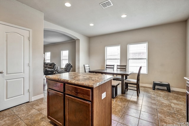 kitchen with crown molding, light tile patterned flooring, and a kitchen island