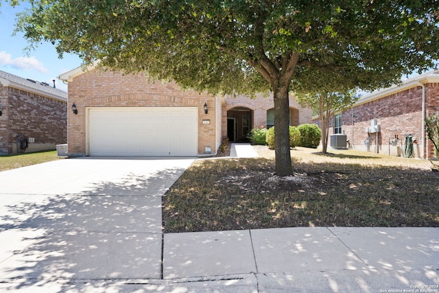 view of front of home featuring a garage and central air condition unit