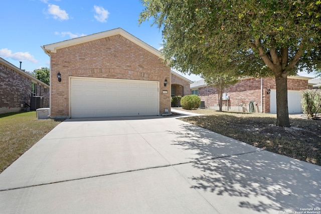 view of front of property featuring a garage and central AC