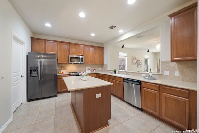 kitchen with light tile patterned floors, stainless steel appliances, a center island, and decorative backsplash