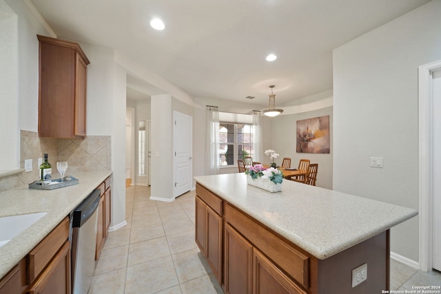 kitchen featuring a center island, decorative light fixtures, tasteful backsplash, dishwasher, and light tile patterned floors