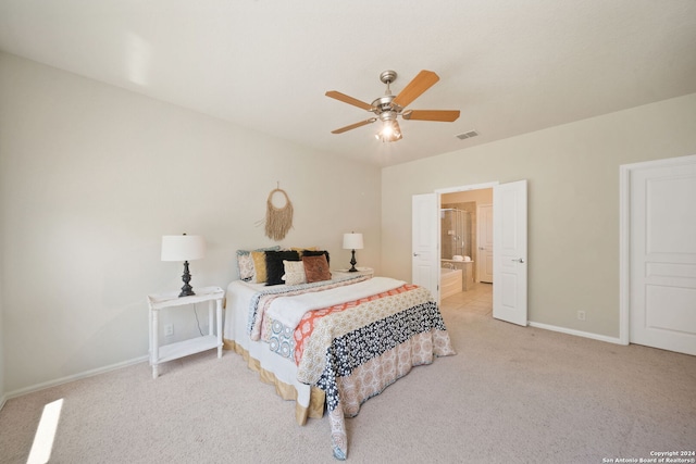 bedroom featuring ceiling fan, ensuite bath, and light colored carpet