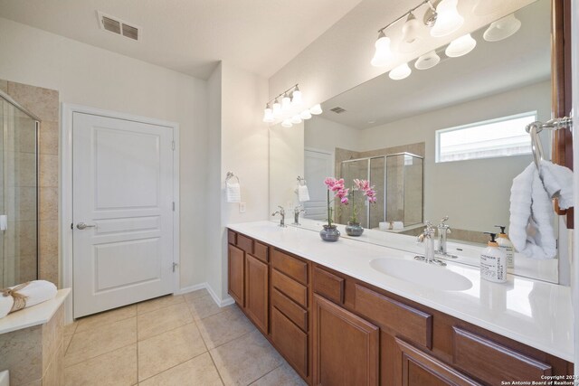 bathroom featuring tile patterned floors, double sink vanity, and a shower with shower door