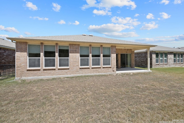 back of property with a patio area and a yard