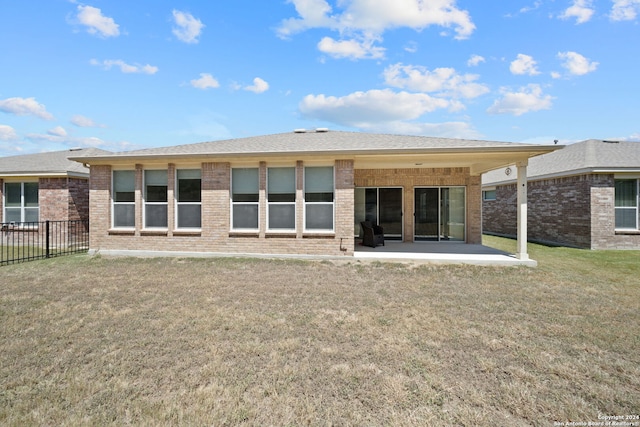 back of property with a patio and a yard