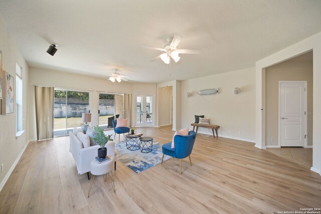 living room with ceiling fan, light wood-type flooring, and french doors