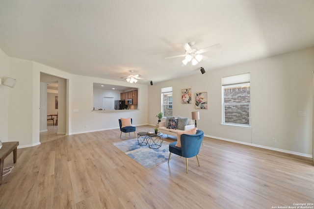 living room featuring ceiling fan and light wood-type flooring