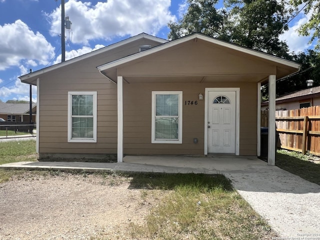 view of front of property featuring driveway and fence