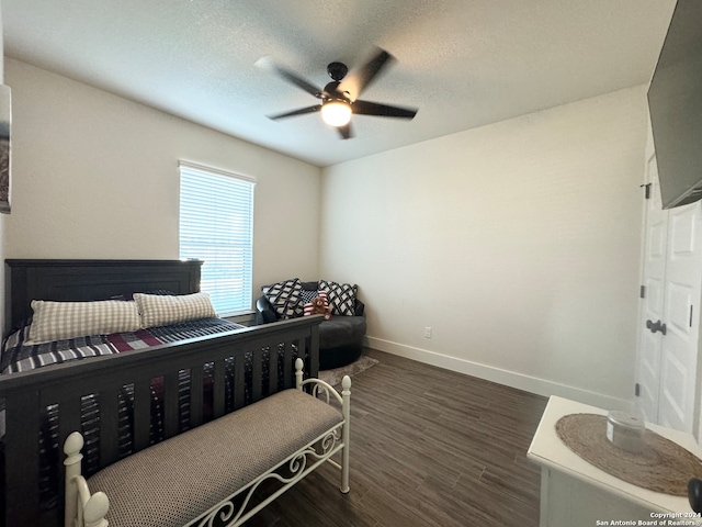 bedroom with dark hardwood / wood-style flooring, ceiling fan, and a textured ceiling