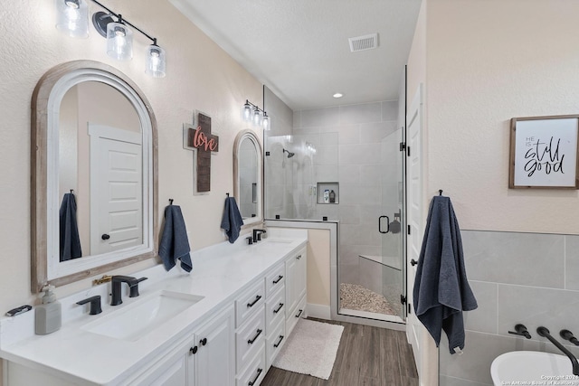 bathroom featuring a shower with door, vanity, and hardwood / wood-style flooring