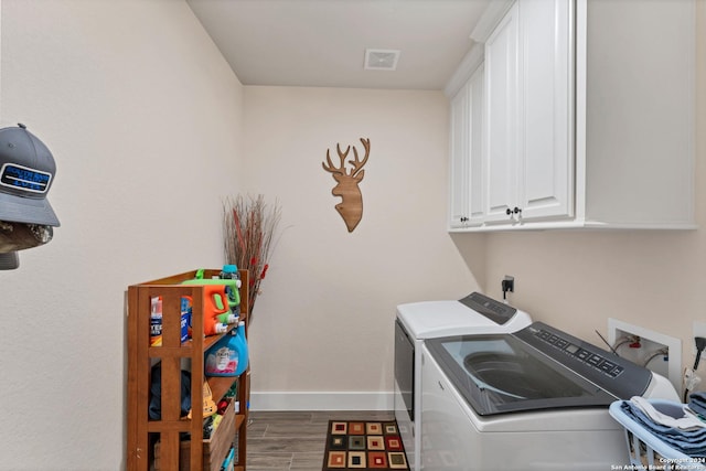 laundry room with cabinets, hardwood / wood-style floors, and independent washer and dryer