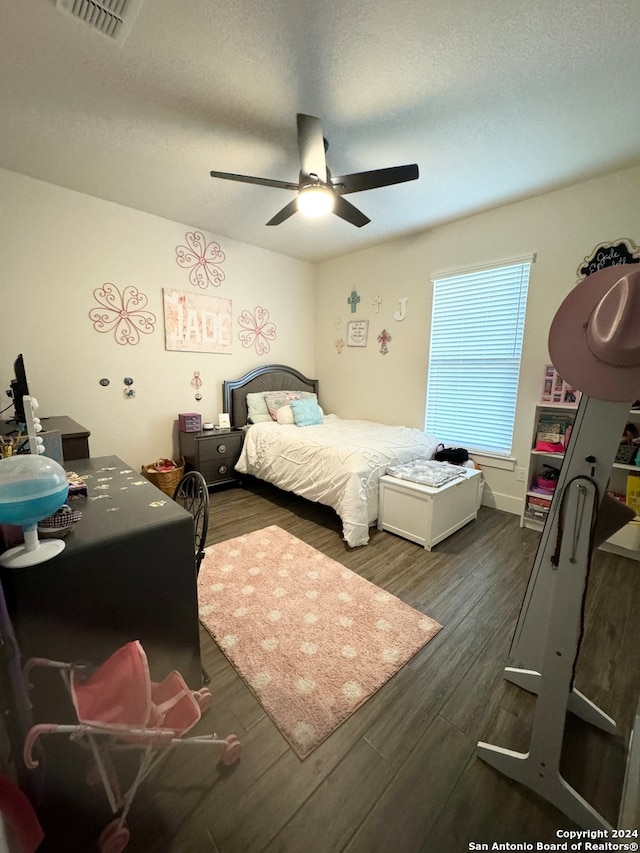 bedroom featuring dark wood-type flooring, ceiling fan, and a textured ceiling