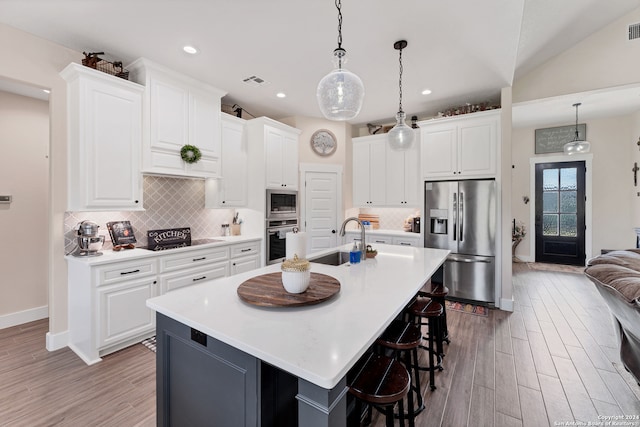 kitchen featuring an island with sink, sink, appliances with stainless steel finishes, and white cabinetry