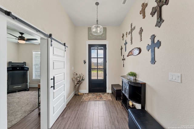 entryway with hardwood / wood-style floors, a barn door, and ceiling fan