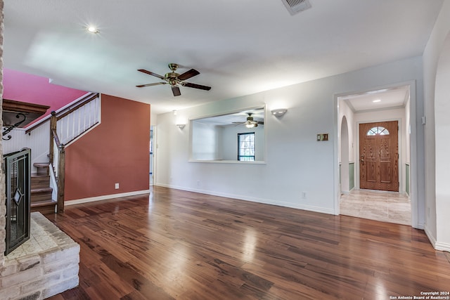 unfurnished living room featuring ceiling fan and dark hardwood / wood-style floors