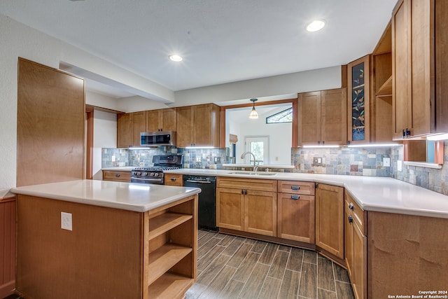 kitchen featuring decorative backsplash, dark wood-type flooring, appliances with stainless steel finishes, sink, and kitchen peninsula